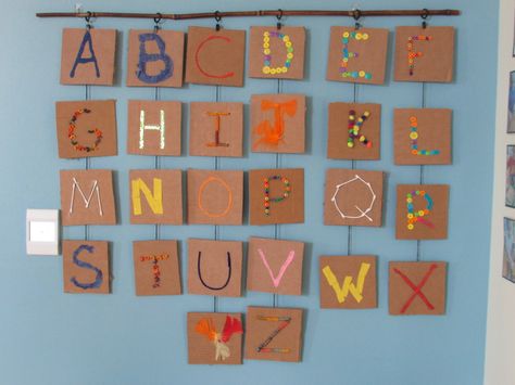 When exploring their five senses and letter identification, children at a Bright Horizons center in KY used recycled cardboard and materials in a variety of textures to create a textured alphabet classroom display. Alphabet Display Preschool, Preschool Classroom Alphabet Display, Reggio Alphabet Display, Alphabet Classroom Decoration, Classroom Alphabet Display, Reggio Emilia Art Projects, Alphabet Display, Reggio Inspired Classrooms, Reggio Classroom