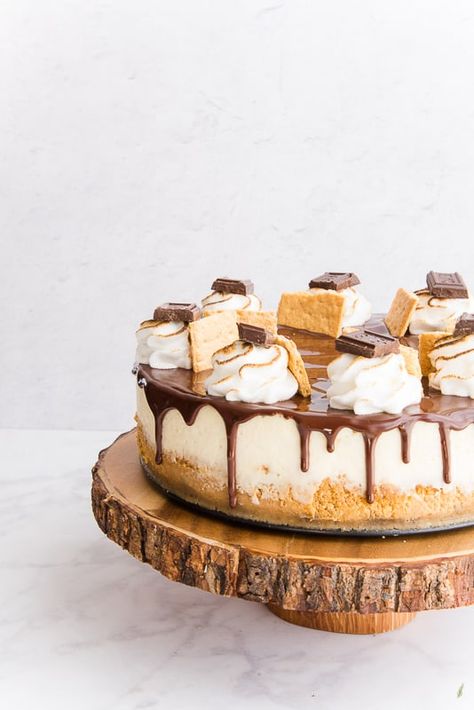 S'mores Cheesecake brings the best of the outdoors inside. Graham cracker crust, toasted marshmallow cheesecake, covered in chocolate ganache and topped with more s'mores yumminess. #smorescheesecake #cheesecake #smores #summer #dessert #cake #chocolate #baking #marshmallow #grahamcrackers #campfire #outdoorcooking S'mores Cheesecake, Smoked S’mores Cheesecake, Cheesecake Factory Smores Cheesecake, S’more Cheesecake, S’mores Cheesecake Recipe, Fancy Cheesecake Recipes, S’mores Cheesecake, Cheesecake Ideas Creative, Cheesecake Flavors Ideas