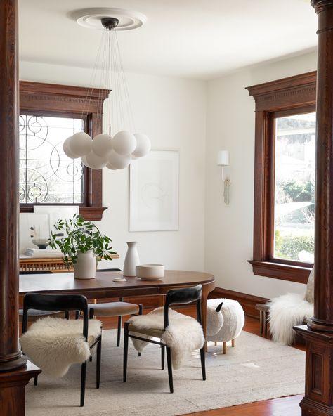 J.L. Møller Model 75 chairs from the fifties—two found in Seattle, two ordered from a dealer in Denmark—surround a vintage Danish table. All of the house’s lighting is white and sculptural: the pendant light is from Jayson Home in Chicago and the Go Lightly Sconces are a Barbara Barry design from Circa Lighting. Hillary happened upon the Sheep Ottoman at Target. Dark Wood Trim, Four Square Homes, Wood Floor Colors, Apartment Lighting, Brighten Room, Bubble Chandelier, Wooden Chairs, 아파트 인테리어, Craftsmen Homes