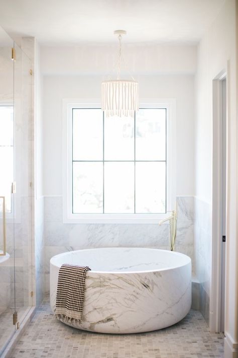 A round marble bathtub in a sparkling white and marble bathroom. Bright, glamorous, simple bathroom design. Bathroom Natural Wood, Cher House, Bathroom Chandelier Lighting, Round Bathtub, Bathroom Natural, Bathroom Chandelier, Marble Bathtub, Marble Tub, Bathtub Design