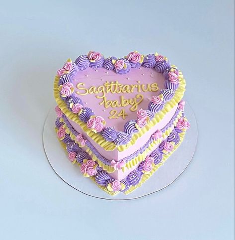 Small heart shaped birthday cake with purple, yellow, and pink icing with Sagittarius baby written on it Saggitarius Cake Design, Sagittarius Baby Cake, 2000s Cake, Sagittarius Birthday Cake, Lambeth Cakes, Sag Season, Shaped Birthday Cake, 24th Birthday Cake, Heart Shaped Birthday Cake