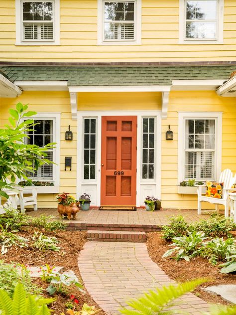 With so much yellow siding, “the house needed a door that would stand out,” says Susie. She and Jerry liked this deep coral so much, they painted the storm door the same color. Yellow House Front Door, Yellow House Exterior, Green Roof House, Orange Door, Yellow Cottage, Yellow House, Exterior Paint Colors For House, Whatsapp Wallpaper, Yellow Houses