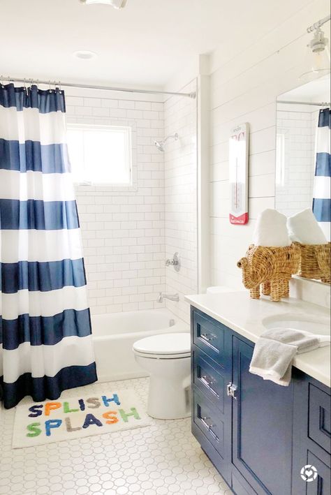 This blue and white bathroom was perfect for my son! We dressed up the space with a cute Splish Splash rug, woven elephant towel holder, and navy vanity! To see more paint colors used in the home, head to the blog! Makeover Kamar Mandi, Farmhouse Bathrooms, Kids Bath Mat, Kid Bathroom Decor, Bubble Baths, Guest Bathrooms, Boys Bathroom, Apartment Bathroom, Diy Bathroom Decor