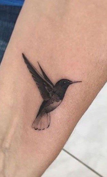 Hummingbird Tattoos: Meanings, Tattoo Designs & Ideas Hummingbird Tattoo Back Shoulder, Hummingbird Tattoo Coverup, Dark Hummingbird Tattoo, Shaded Hummingbird Tattoo, Traditional Hummingbird Tattoo Black, Black Hummingbird Tattoo, Bird Ankle Tattoo, Hummingbird Tattoo Black, Goth Tattoo