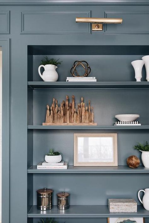 Blue Library, Vintage Wicker Chair, Den Library, Light Grey Kitchen Cabinets, Brass Picture Light, Blue Shelves, Light Grey Kitchens, Light Gray Cabinets, Bookcase Lighting