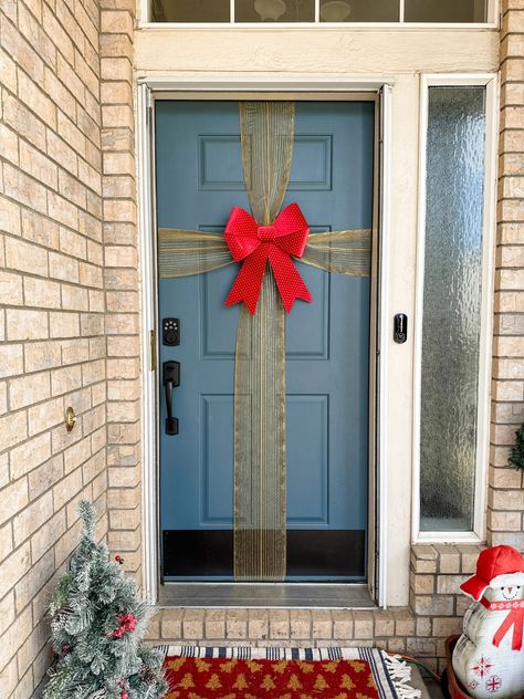 Try This Christmas Bow for Your Front Door (Plus 3 Other Christmas Door Decorations!) Try This DIY Front Door Christmas Bow! Ribbon Front Door Christmas, Bow On Front Door Christmas, Front Door Present Decoration, Diy Garage Door Christmas Decor, Tulle Bow Front Door Christmas, Wrapping Paper On Door, Christmas Door Ideas For Apartments, Christmas Bow Front Door, Door Bows Christmas Diy