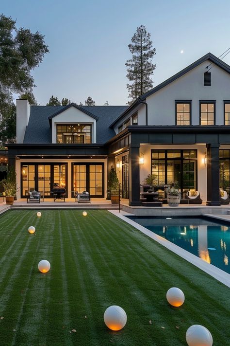 Modern house with large windows, a well-manicured lawn, and a swimming pool at dusk. Small Luxury Backyard Ideas, Large Grass Backyard Ideas, Turf Grass Backyard Ideas, Turf And Pavers Backyard Pool, Fake Grass Backyard Ideas, Turf In Backyard, White House Backyard, Turf Landscaping Ideas, Grass Patio Ideas