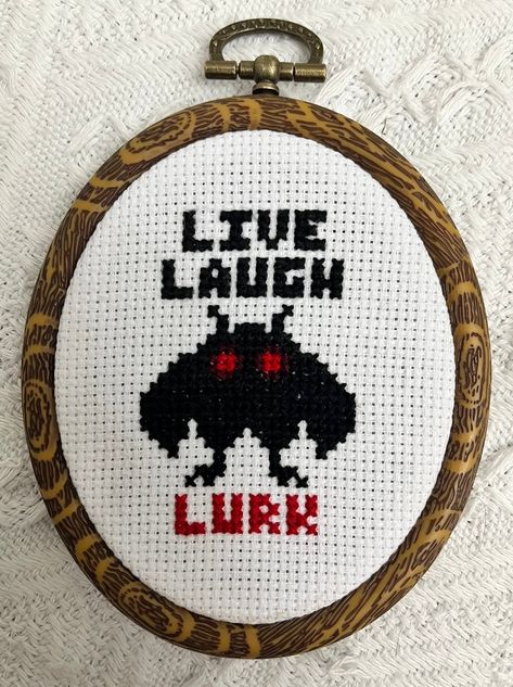 "Live, Laugh, Lurk! Download this cute Mothman cross stitch pattern. The image shown is done on 14 ct AIDA and in an embroidery hoop that's about 4.5\" x 3.75\"! The pattern is complete with a chart and DMC color list. This pattern is for PERSONAL USE ONLY. If you would like to purchase it for commercial use (to sell finished products) please send me a message and I will create a listing for commercial use." Chaotic Cross Stitch, Come Back With A Warrant Cross Stitch, Live Laugh Lurk, Mothman Cross Stitch Pattern, Sweary Cross Stitch, Mothman Pixel Art, Queer Cross Stitch, Silly Cross Stitch, Mothman Embroidery