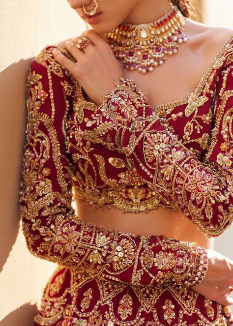 Embellished Choli Lehenga Style Pakistani Bridal Dress has an alluring deep red color and is heavily embellished with intricate designs and ornaments. Shimmering ornaments and goldwork make this stunning Bridal Lehenga Choli your priority to have a magical wedding look. Raw silk Choli: The beautiful choli in premium raw silk fabric has a beautiful deep red shade and is beautifully adorned with hand-crafted details of dabka, tilla, sequins, beads, and zardosi. Goldwork and shimmering details make Stylish Lehenga Designs, Nameera By Farooq, Crystal Work, Lehenga Bridal, Raw Silk Fabric, Bridal Lehenga Red, Wedding Lehengas, Lehenga Style, Red Lehenga