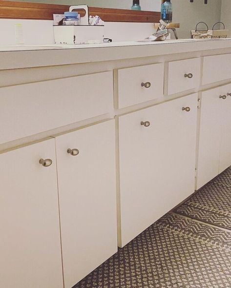 I recently decided to give my bathroom a budget-friendly makeover. Instead of replacing the bathroom vanity, I decided I would add shaker trim to the flat panel doors and paint the vanity to look brand new. Checkout the detailed videos on my IG: instagram.com/mrsashleyfrench Remove doors and hardware First I removed the hardware off the cabinets. Then I removed the doors by unscrewing the hinges. I completely removed the hinges from the doors and placed the hinges, screws, and ha… Flat Panel Bathroom Cabinets, Adding Trim To Bathroom Vanity, Flat Panel Bathroom Vanity, Flat Cabinet Doors Makeover, Cabinets With Exposed Hinges, Adding Trim To Kitchen Cabinets, Flat Kitchen Cabinets, Shaker Trim, Flat Cabinet Doors