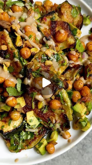 Caitlin Latessa-Greene on Instagram: "SMASHED ZUCCHINI & CHICKPEA SALAD WITH AVOCADO &  PISTACHIOS! Try smashing your zucchini—so tender with a little crisp 🩷 • For the salad:  3 large zucchini  Salt 2 tbsp olive oil  1 tsp paprika ½ tsp garlic powder  ¼ cup chopped cilantro  ⅓ cup finely chopped red onion 1 avocado, finely chopped ¼ cup pistachios Tahini, optional for topping • For the chickpeas:  1 15-oz can chickpeas, rinsed and drained ½ tbsp olive oil 1 tsp paprika ¼ tsp salt ½ tsp garlic powder • 1️⃣Preheat the oven to 425. 2️⃣Place the zucchini down onto a cutting board or the counter. Use a rolling pin or a heavy pan to smash the zucchini into medium sized pieces. Repeat with the remaining zucchini. 3️⃣Next, place the zucchini into a colander then sprinkle liberally with salt. Let Smashed Zucchini And Chickpea Salad, Smashed Zucchini With Chickpeas, Smashed Zucchini, Zucchini Chickpea, Large Zucchini, Salad With Avocado, Cauliflower Dishes, Cilantro Lime Dressing, Zucchini Salad