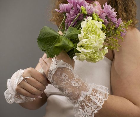 These  fingerless lace floral lace gloves are perfect to complete a coquette vintage bridal look, or just to add a little extra dash of elegance to your outfits. The gloves are made of delicate white lightweight nylon lace fabric with flowers, making them perfect for a bridal look, or versatile to pair with other items in your closet. A satin fingerloop with a delicate satin bow and two faux pearl beads helps the gloves stay in place, in addition to elastic at the forearem trimmed with additional lace for an extra floof of flair as dramatic as your outfit. The forearm elastic allows for varied styling for added versatility. These gloves have some stretch but  intended to fit most hand sizes. See measurements for proper fit.  Model in black dress in photos wears a glove size 6. Model in whi Costume Gloves, Gloves Vintage, Magical Accessories, Formal Gloves, Bridal Gloves, Coquette Vintage, Lace Gloves, Vintage Bridal, Satin Bow