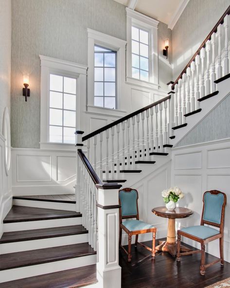 Dark-stained hand rails and stair treads set off the white millwork on this traditional, winding staircase. A trio of casement windows escalates along the steps, and wainscoting gives the space a sense of traditional elegance. Staircase Window, Patrick Ahearn Architect, Stairs Window, Foyer Staircase, Traditional Staircase, Staircase Remodel, Staircase Wall, Stairway Design, Casas Coloniales