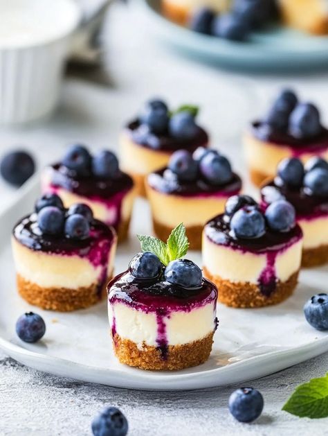 Mini Blueberry Cheesecakes 🫐  🫐 𝗜𝗻𝗴𝗿𝗲𝗱𝗶𝗲𝗻𝘁𝘀 🫐 Blueberry Sauce Topping: 2 cups fresh or frozen blueberries 🫐 1/2 cup granulated sugar 🍬 5 tablespoons peach fruit nectar (or any flavor) 🍑 1 tablespoon cornstarch (optional) 🌾 1 tablespoon water (optional) 💧 Cheesecake Crust: 9 full sheets of graham crackers 🍪 2 tablespoons granulated sugar 🍬 3 tablespoons butter, melted 🧈 Mini Peach Cheesecake, Blueberry Cheesecake Tart, Blueberry Cake Pops, Baking Pictures, Mini Blueberry Cheesecakes, Cheesecake Blueberry, Peach Cheesecake, Cheesecake Parfaits, Cheesecake Crust