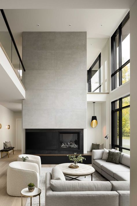 A modern living room with a fireplace has a double-height ceiling and a wall of windows. Living Room With A Fireplace, Double Height Living Room, Cottage Fireplace, Contemporary Home Design, Small Bungalow, Wood Exterior, Condo Remodel, Decor Fireplace, Double Height