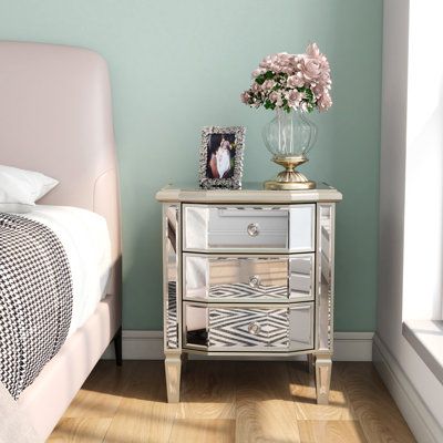 Whether sitting on the sofa or snuggling next to the bed in the master suite, this mirrored 3-drawer nightstand can inject a stunning style into your space. This silver nightstand is made of engineered wood and glass and comes with 3 drawers with pull-ring-type handles. The mirror surface will capture beautiful light and create a charming, shiny look in your bedroom and living room. We love that the drawers are set on smooth roller glides. Best of all, it arrives fully assembled for a fuss-free Nightstand Vintage, Silver Nightstand, Wide Bedside Table, Mirror Nightstand, Glass Nightstand, Mirror Drawers, Vintage Border, Stylish Table Lamps, Bedside Table Design