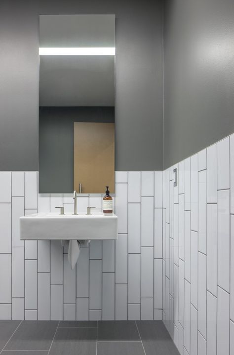 bathroom. long subway tile, vertical running bond, chair rail - Bicycle Haüs / Debartolo Architects Commercial Bathroom Designs, Toilette Design, Restaurant Bathroom, Subway Tiles Bathroom, Restroom Design, Best Bathroom Designs, Bathroom Installation, White Subway Tiles, Public Bathrooms