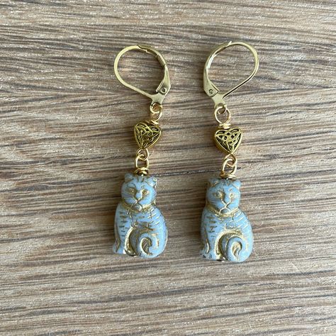 Handmade Czech Glass Gray Cat Bead Earrings Have Gold Celtic Heart Beads Approximately 1.75” Gold Plated Lever Back Ear Wires Silvery Gray Czech Glass Cat Beads Have Gold Features And Trim Tiny Gold Plated Hearts Have A Celtic Knot On Them Handcrafted By Me Gift Boxed, Ready To Wrap My Earrings Always Have $4.99 Shipping! I Always Ship Same Day Or Next Business Day Custom Orders Are Always Welcome Any Questions, Please Ask! Save $$ Bundles Of 2 Or More Items Automatically Receive A 20% Discount! Czech Beads Jewelry, Cat Beads, Pom Crafts, Czech Glass Jewelry, Tree Of Life Earrings, Celtic Heart, Glass Cat, Cat Bead, Casual Earrings