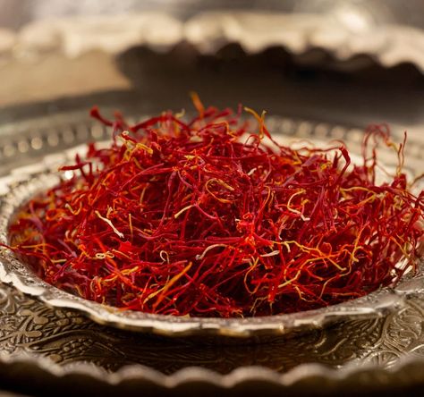 Close-up of a pile of red saffron threads on an intricately designed silver plate, with a soft, blurred background Saffron Uses, Saffron Tea, Saffron Benefits, Crocus Sativus, Saffron Crocus, Saffron Extract, Face Treatments, Saffron Threads, Cooking Essentials