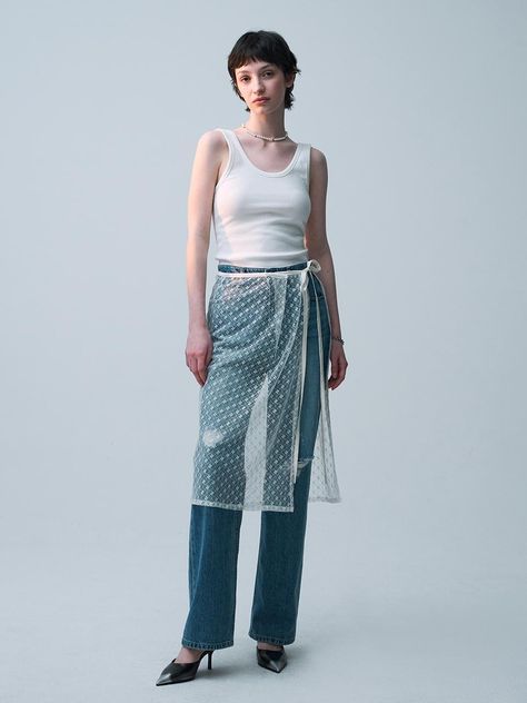 This product is an innovative lace wrap skirt that overlays a pair of classic jeans, offering a unique blend of textures and styles. The skirt features a delicate lace pattern with a translucent appearance, adding a layer of sophistication and visual interest. It ties at the waist with a sleek, adjustable ribbon, allowing for a customized fit while highlighting the contrast between the rugged denim and the refined lace. - This skirt features a distinctive lace design that wraps around and ties at the waist, providing a versatile and adjustable fit.- The lace is designed with an intricate pattern that adds a touch of elegance and complexity to the overall appearance.- Paired with rugged denim jeans, the lace offers a striking contrast that blends casual and upscale fashion elements.- T Lace Skirt Over Jeans, Skirt Jeans Outfit, Rugged Denim Jeans, Asymmetrical Skirt Outfit, Skirt Over Jeans, Lace Trend, Lace Outer, Upscale Fashion, Fashion Elements