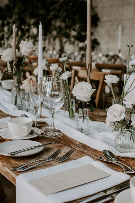 25+ Modern Monochromatic Wedding Florals & Decor Ideas • VintageBash Candle And Floral Tablescape, White Roses In Vase Table Flowers, Cheesecloth Runner Bud Vases, Wedding Neutral Table Setting, Head Table Bud Vases And Candles, Bud Vase Table Setting, Muslin Table Runner Wedding, Long Table Wedding Set Up, White Bud Vases Wedding Centerpiece