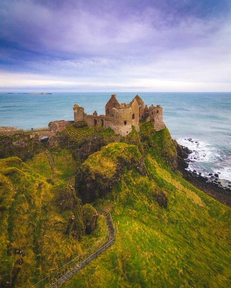 Northern Ireland travel. Dunluce Castle, Northern Ireland – Epic Medieval Castle on the Cliffs - Dunluce Castle is a castle in Northern Ireland, built on top of cliffs, and connected to mainland by a small bridge. It even has a massive cave underneath! #ireland #irelandtravel #travelguide #cityscape #castle #europetravel #travelguide #gameofthrones #traveldestinations Northern Ireland Itinerary, Antrim Ireland, Dunluce Castle, Northern Ireland Travel, Ireland History, Ireland Road Trip, Dark Hedges, Ireland Photography, Castles In Ireland