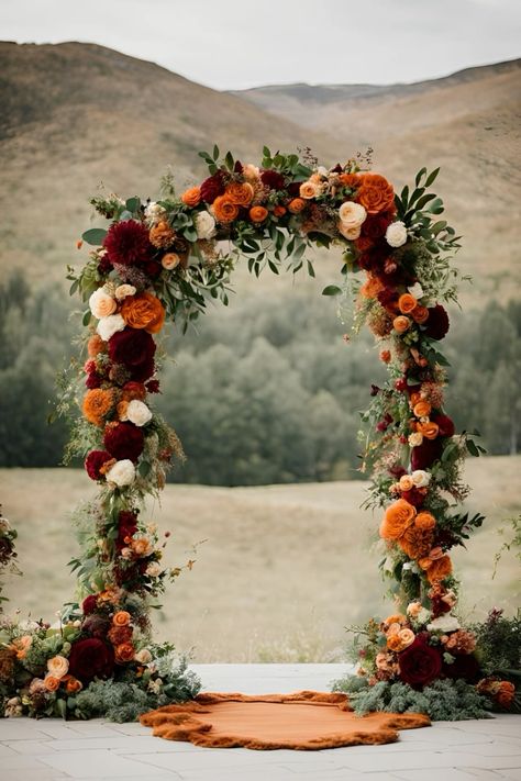 Floral wedding arch: earthy tones wedding colour themes    #floralwedding #flowerweddingarch #floralarch #fallwedding #fallweddingarch #fallweddingflowers #earthtoneswedding #earthytonesweddingtheme #earthytonesweddingcolours #burntorangewedding #rusticwedding #burgundywedding October Wedding Arch Ideas, Wedding Colours September, Fall Wedding Eucalyptus Decor, Fall Themed Wedding Arch, Fall Country Wedding Decorations, Budget Fall Wedding Decor, Autumnal Wedding Arch, Rust And Burgundy Wedding Decor, October Wedding Outside