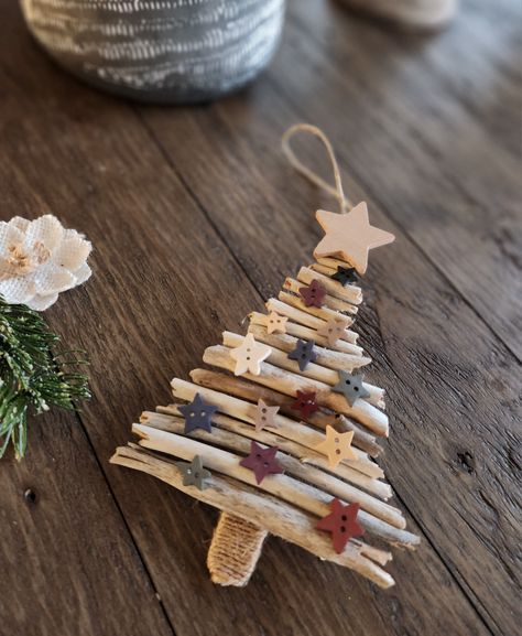 Rustic Christmas tree ornament made from driftwood and popsicle stick with wood star embellishments and twine around the tree stump Christmas Stick Crafts, Recycled Tree Craft, Dowel Christmas Tree Diy, Christmas Tree With Sticks, Driftwood Xmas Tree, Driftwood Christmas Trees, Nature Christmas Tree Decorations, Driftwood Christmas Crafts, Driftwood Ornaments Diy