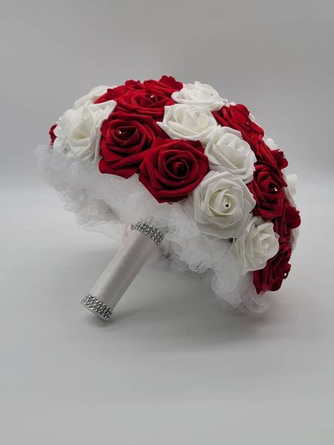 Each bouquet is handmade to order using real touch roses. A rhinestone is placed in the center of every rose. Handle is made up of your choice of satin ribbon and handle accessories: Brooch: Silver, Gold, Or Rose Gold Bling wrap: Silver, Gold, Rose Gold, No accessories Bouquets are available in 4 sizes: 6 inch 8 inch- Pictured in listing 10 inch 12 inch-Pictured in listing Matching Boutonnieres and corsages available in listing below...Or see store for all styles of boutonnieres and corsages you Roses Bridal Bouquet, Red And White Wedding, White Rose Wedding Bouquet, Red Bridal Bouquet, Calla Lily Bouquet Wedding, Black Bouquet, White Boutonniere, Calla Lily Wedding, Red And White Weddings