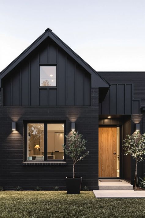 Charcoal brick farmhouse exterior featuring black windows, vertical siding, and modern lighting with white mortar detail Black Windows Exterior Modern, Farmhouse Black Windows Exterior, Black Metal Roof Farmhouse, Farmhouse Black Shutters, Windows Exterior Modern, Black Stone House Exterior, Farmhouse Exterior Black, Farmhouse Black Windows, Metal Roof Farmhouse