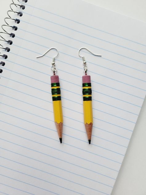 "Ticonderoga Pencil Earrings Get ready for Back to School with these pencil earrings! Made from the \"World's Best Pencil\" ✏️ Perfect gift for Teachers and Artists! :: DETAILS :: - Made with real pencils - Size is approximately 3.25 inches - Hypoallergenic ear wires If you like this item, you might also like >> Crayon Earrings : https://www.etsy.com/listing/800576416/crayon-earrings-l-crayola-earrings-l Colored Pencil Earrings : https://www.etsy.com/listing/1215461587/colored-pencil-dangle-earr Pencil Clay Earrings, Teacher Earrings Diy, Ticonderoga Pencil, Gifts For Artist, Crayon Earrings, School Earrings, Pencil Earrings, Teacher Jewelry, Teacher Hair