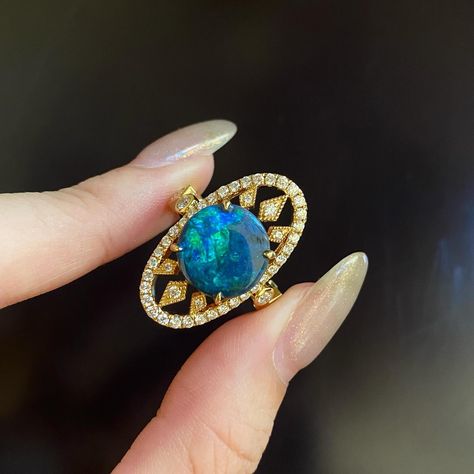 It’s bold, it’s got that architect vibe, and it’s just dripping with elegance 🪐 This piece centers around an Australian black opal, known for its rich, oceanic color play, set in a shield-shaped gold frame that adds a touch of drama. The opal is the star here, but the supporting cast isn’t shy either—small diamonds are sprinkled across the band, giving that extra sparkle. It’s all tied together on a gold band that’s got a bit of heft, balancing the opal’s natural beauty with a sturdy, luxe f... Luxury Blue Opal Ring Elegant Style, Luxury Blue Opal Ring, Luxury Celestial Opal Ring, Luxury Yellow Gold Opal Ring Collectible, Luxury Elegant One-of-a-kind Opal Ring, Australian Black Opal, Star Jewelry, Black Opal, Gold Frame