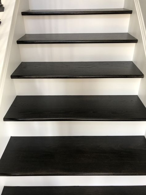 Ebony stain by Sherwin-Williams stair treads on a new build. We did 2 coats I didn’t want it too Black as I was wanting to still see the oak grain. However I probably would have had the painter done 3 coats and it would have been perfect. Still looks amazing. Paint Stair Treads Black, Black Treads White Risers, Black Stained Wood Stairs, Black Stain Staircase, Stained Black Stairs, Black Stairs Light Floors, Black And White Wood Stairs, Black Wood Stain Stairs, Dark Stained Staircase