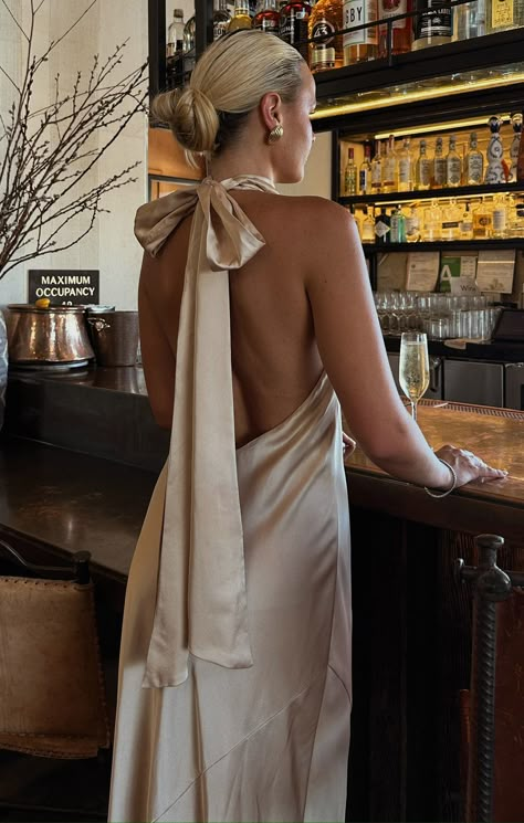 Whether you're walking down the aisle as a bridesmaid or turning heads as a guest, the Lisa Maxi Dress is your go-to for all the events this season. With its chic halter neckline, fluttery scarf tie, and dreamy mermaid cut, it hugs your curves to create a stunning hourglass silhouette. You’ll look enchanting from every angle! Champagne Halter Bridesmaid Dress, Vintage Maid Of Honor Dress, Bridesmaid Dresses In Champagne, Tan Silk Bridesmaid Dress, Satin Dress Colors, Bridesmaid Dress For Beach Wedding, Champagne Bridesmaid Dresses And Grooms, Champagne Long Dresses, Champagne Coloured Bridesmaid Dresses