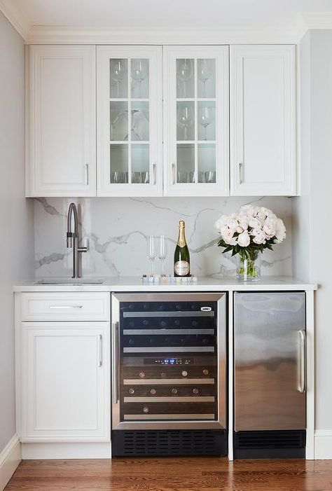 Beautiful white wet bar features glass front cabinets mounted between white raised panel cabinets fitted above a square sink with a satin nickel gooseneck faucet. Kitchen Wet Bar, Home Wet Bar, Basement Bar Designs, Small Basements, Home Bar Designs, Cocktails Bar, Kitchen Inspiration Design, Counter Tops, Wet Bar