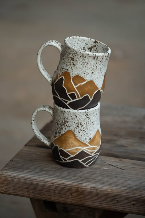 Handmade mugs decorated with sgraffito designs - OOAK and filled with love! These cups are of a B mix white clay body, decorated and made functional with a beautiful earthy speckled crème glaze. At the bottom, you'll feel the earthiness of raw-kept underglaze.  This is a listing for the SET of 2 mugs with handles as shown in the images - though, these will be made to order and thus will slightly, barely noticeably, differ. These cups are not dishwasher- or microwave safe. Sculptural Mug, Pottery Espresso Cups, Mug Ceramic Ideas, Pottery Gifts For Men, Ceramic Mug Designs, Ceramic Mugs Handmade, Carving Pottery, Sgraffito Designs, Creative Mugs