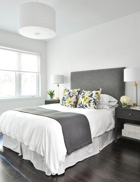 Beautifully design charcoal gray bedroom showcases a gorgeous charcoal gray upholstered headboard placed behind a bed dressed in white hotel bedding accented with a gray throw blanket and yellow and gray floral pillows. Bedroom Ideas Grey Headboard, Charcoal Gray Bedroom, Charcoal Grey Bedrooms, Charcoal Headboard, Bedroom Ideas Grey, Grey Headboard Bedroom Ideas, Grey Headboard Bedroom, Gray Throw Blanket, Charcoal Bedroom