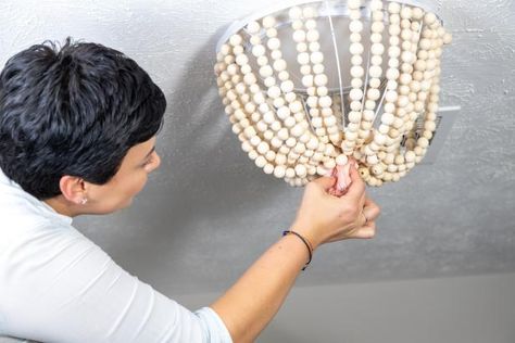 How to Make a Beaded Boho Flush-Mount Light Fixture | HGTV Beaded Light Fixture, Boho Style Lighting, Wooden Bead Chandelier, Chandelier Diy, Boho Chandelier, Wood Bead Chandelier, Painted Baskets, Diy Light Fixtures, Colored Ceiling