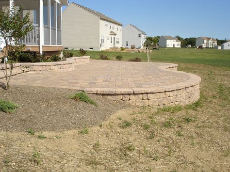 Elevated paver patio with retaining wall Stone Wall Around Patio, Covered Patio With Retaining Wall, Patio With Retaining Wall And Steps, Elevated Patio With Retaining Wall, Paver Patio With Retaining Wall, Fire Pit Patio With Retaining Wall, Elevated Paver Patio, Stamped Patio With Retaining Wall, Paver Deck Raised