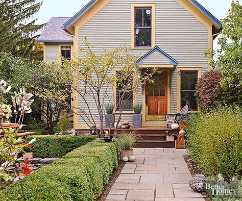 Camel-painted trim emphasizes this home's shape to make it appear wider and taller; the rich camel tone shows up again to bring out the windows and entry door. Eggplant-hue window frames sound a playful note and work with periwinkle blue details to add architectural interest to the plainly profiled abode. Take a close look at the roof shingles, and you'll see where the homeowners found inspiration for the blue and purple accent tones. Stone Sidewalk, Spiky Plants, Paint Stairs, Exterior Color Combinations, Stain Concrete, Cracked Concrete, Colored Concrete, Concrete Path, Green Shutters