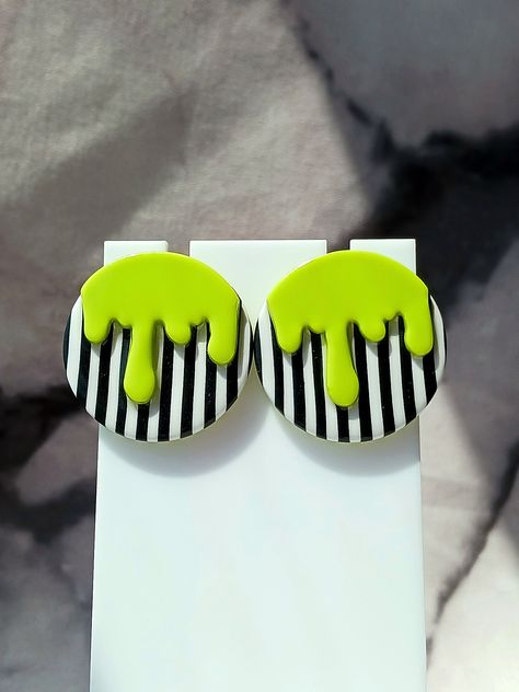 These Drippy studs were inspired by the movie Beetlejuice. They were handmade using polymer clay. The base was made using Black and White polymer clay. The drips were made using Bright Green/Chartreuse polymer clay. They have a layer of UV resin for added durability and shine. Stainless steel posts. Lead and Nickle free. Size - 1" Each piece is handmade and sanded. There may be small imperfections and no two are exactly alike. You may receive the earrings pictured or a similar pair. Polymer Clay Halloween Earrings Diy, Goth Polymer Clay, Beetlejuice Clay, Beetle Juice Clay Earrings, How To Make Polymer Clay Earrings, Beetlejuice Clay Earrings, Beetlejuice Inspired Jewelry, Halloween Earrings Diy, Beetlejuice Green