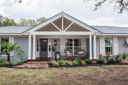 Fresh landscaping with ornamental grasses and a dwarf palm also contribute to an underlying coastal theme. Front Porch Addition, Farmhouse Style Exterior, Ranch House Remodel, Ranch House Exterior, Porch Remodel, Ranch Remodel, Porch Addition, Brick Ranch, Farmhouse Landscaping