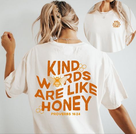 "Kind Words Are Like Honey", design on chest, doodle graphic adorns back side. Brand: Comfort Color T-Shirt, Gildan Crewneck Sweater Color: Ivory T-shirt, White Crewneck  >> If you would like to customize on a different color/style garment, please message me and we can create together :) Size up one or two sizes for an oversized fit.  --- --- --- --- --- --- --- --- --- --- --- WASHING INSTRUCTIONS --- --- --- --- --- --- --- --- --- --- --- For best results, wash on cold/delicate cycle, hang dry, do not iron directly onto design, do not dry clean. No fabric softener. SHOP ANNOUNCEMENTS --- --- --- --- --- --- --- --- --- --- I regularly update my turnaround timeframe. These timeframes can be found in the "Shop Announcement" section. However, please keep in mind once the packages are dropp Easy Shirt Designs, Cute Shirt Ideas, Kind Words Are Like Honey, Words Are Like Honey, Christian Clothes, Christian Tee Shirts, Christian Graphic Tees, Christian Tshirt Design, Jesus Clothes