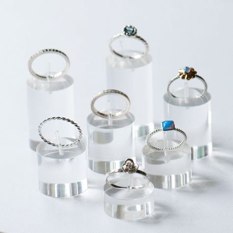 Set of seven ring stands made from clear acrylic. The ring stands are all at different heights so you can mix and match them to make interesting displays for your shop or stand. You can arrange them in a cluster or in a line... so you have a statement look for your ring displays The ring stands have a pin clip on top to support the ring The ring stands are all 23mm in diameter & heights are as follow. The highest is 40mm & the lowest is 10mm high. Tallest : 40mm high 35mm high 30mm high 25mm hig Rings Display Ideas, Rings Display With Metal Piping, Ring Display Stands, Colorful Acrylic Jewelry Stand, Retail Jewelry Display, Acrylic Fragrance Display Stand, Acrylic Fragrance Display Stand For Sale, Ring Display, Ring Holders