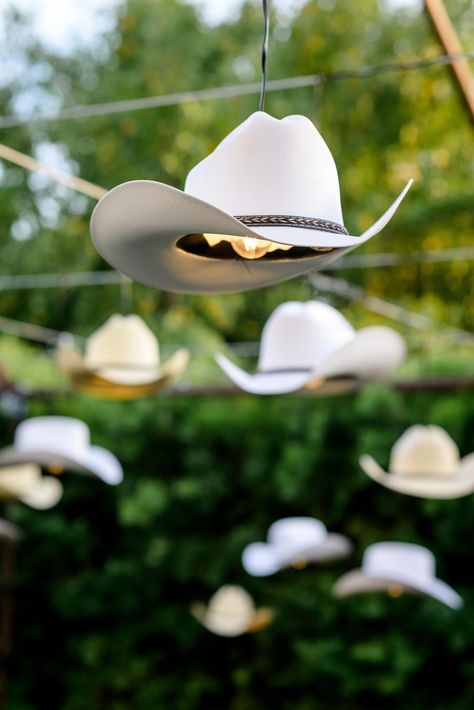 Cowboy hat pendant lamps in natural. and white hanging in outdoor wild west themed party | outdoor lighting ideas, outdoor pendant lamps, cowboy pendant lamps, wild west party ideas, outdoor birthday lighting, cowboy wedding ideas, pendant lamps, luxury event lighting, luxury event decor, wild west party, luxury wedding design, neutral wedding decor #weddinglighting #outdoorweddingdecor Wild West Party Theme, Birthday Lighting, Wild West Wedding, Best Wedding Themes, Western Party Decorations, Country Themed Parties, Wild West Theme, Western Birthday Party, Wild West Party