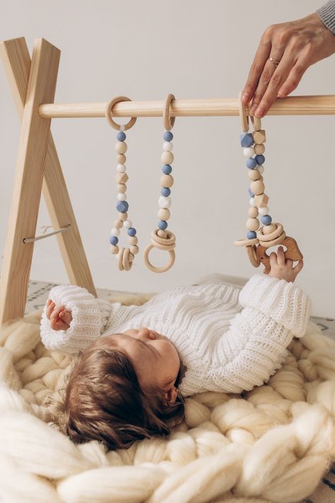 Designed with a Montessori-inspired approach, baby play gym with hanging toys are an excellent first toy for your baby! With its cute toys and neutral colors, this set will blending with any decor. Modern, minimalist, stylish and unique newborn toy. Gender neutral and natural. A must-have for babies and a perfect gift idea for for any occasion: birthday, christening, a baby shower and more. See you in our Etsy shop! ♡ Baby Hanging Toys, Wooden Play Gym, Wooden Baby Gym, Baby Gym Toys, Baby Play Gym, Baby Sensory Toys, Newborn Toys, Play Gym, Nursery Storage