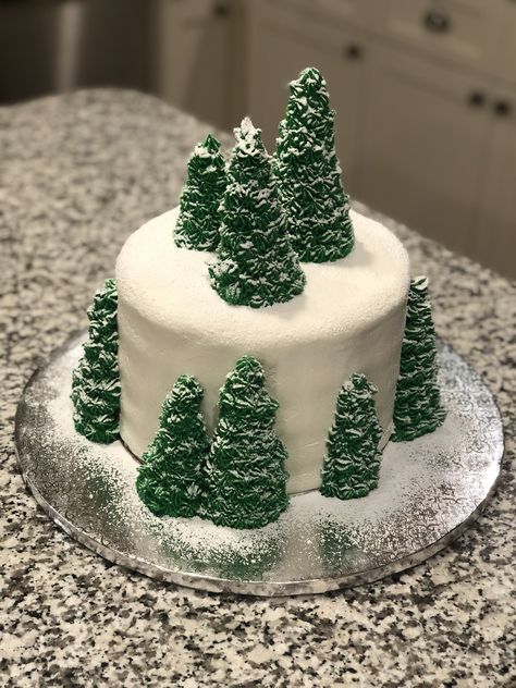 Cake frosted with buttercream.  Trees made using ice cream cones and buttercream with star tip.  Snow made with powdered sugar and luster dust. Green Buttercream Frosting, White Iced Cake, Christmas Tree Ice Cream, Fondant Tree, Green Buttercream, Christmas Ice Cream Cake, Mountain Cake, Snow Cake, Winter Wonderland Cake