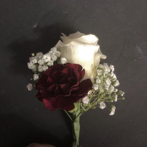 Groom's boutonniere with a white rose, burgundy mini carnation and baby's breath Burgundy Boutonniere Wedding, Burgundy Carnation Boutonniere, Wedding Boutineers Burgundy, Burgundy And White Boutonniere, Burgundy Rose Boutonniere, Burgandy Boutinere Ideas Groomsmen, Burgundy And White Flowers, Burgundy Carnation Bouquet, Burgundy Corsage And Boutonniere