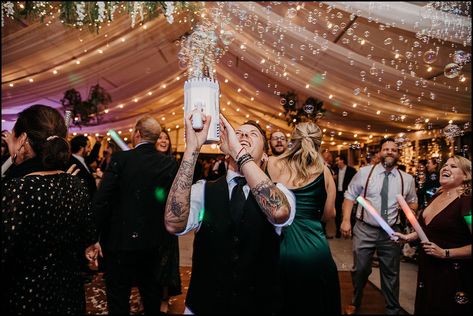 A wedding guest points a bubble gun in the air and fills a wedding tent with bubbles. Bubble Machine Wedding, Wedding Exit With Bubbles, Wedding Ceremony Bubbles, Bubble Blowing At Wedding, Bubble Machine Wedding Exit, Bubble Grand Exit Wedding, Small Wedding Party, Buffalo Wedding, Winter Wedding Photos