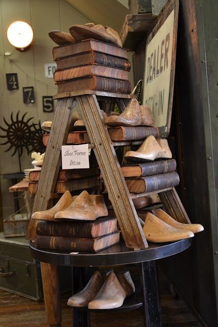 Good use of books and a step ladder to create height and different levels. Could use on a craft fair table and place product in place of shoes. Antique Booth Displays, Antique Booth Ideas, Old Ladder, Market Displays, Craft Show Displays, Creative Display, Vintage Display, Shoe Display, Booth Display